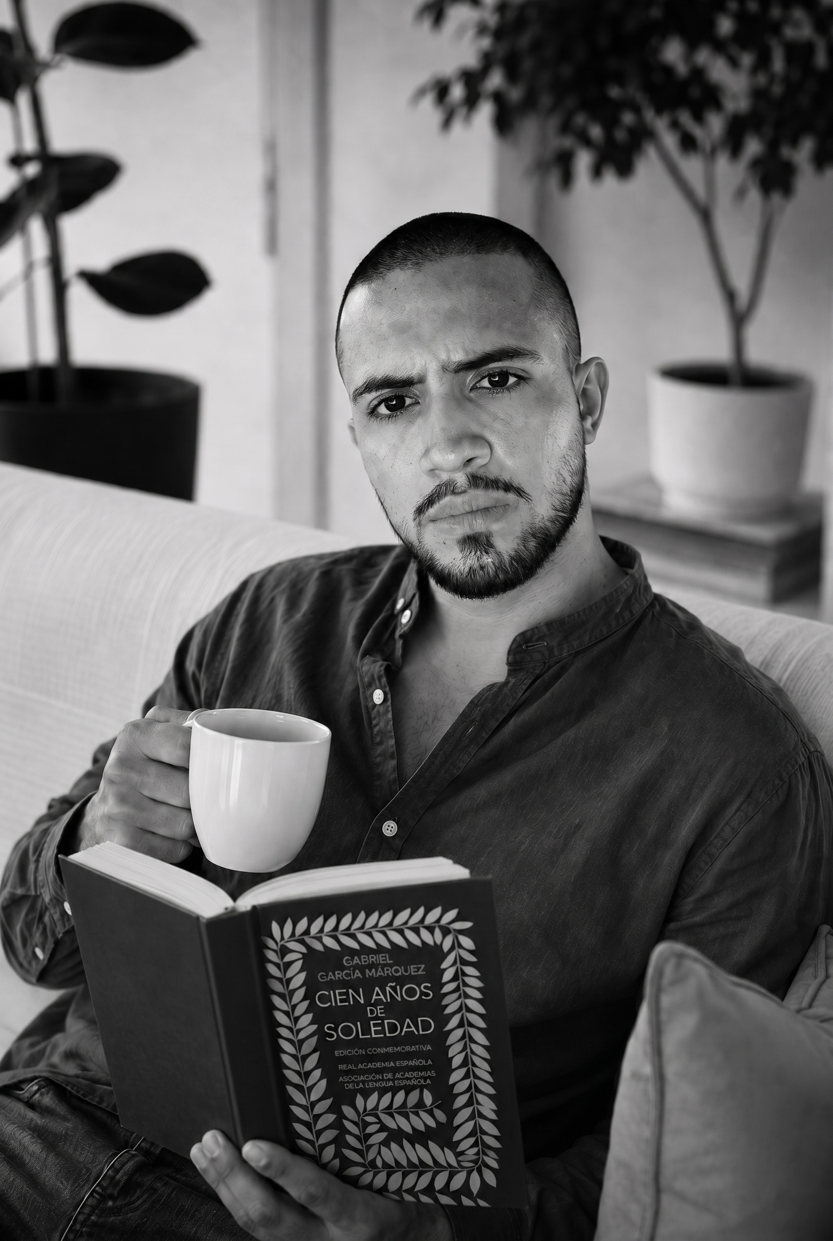 Edward Morrón leyendo en el sofá, retrato en blanco y negro
